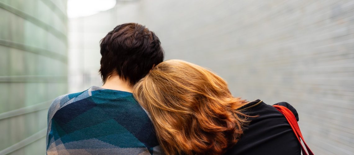 a woman rests her head on another person's shoulder
